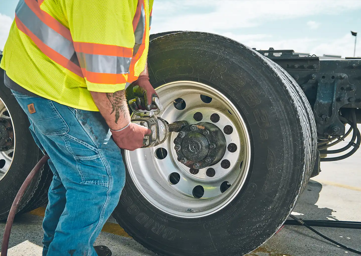 a tire tech removes lug nuts from a commercial tire