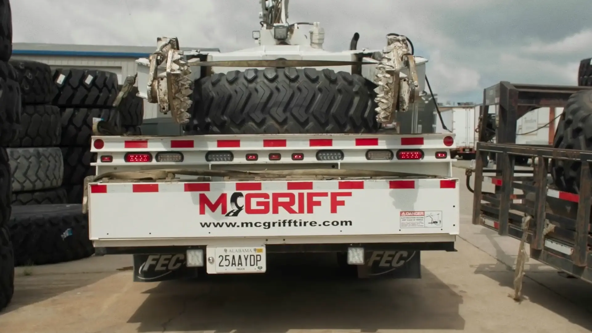 the rear of a mcgriff tire truck carrying a large tire